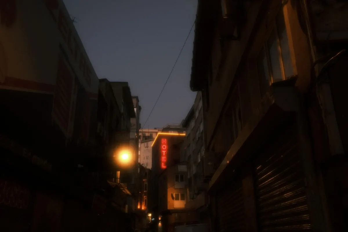 A city street at dusk lit by warm neon signs